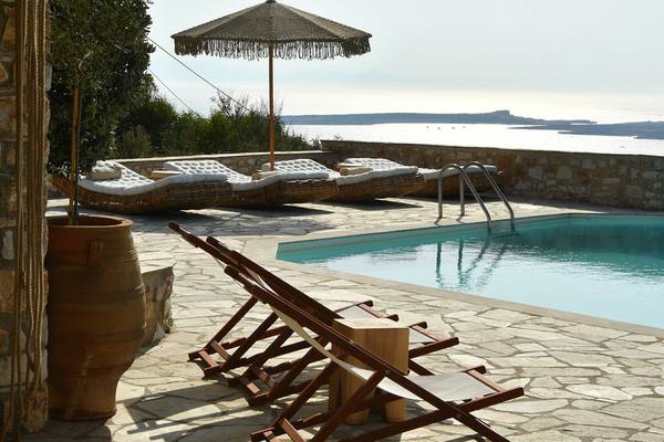 Mythic Hotel mit Pool, Lounge-Sesseln und einem Blick auf das Meer