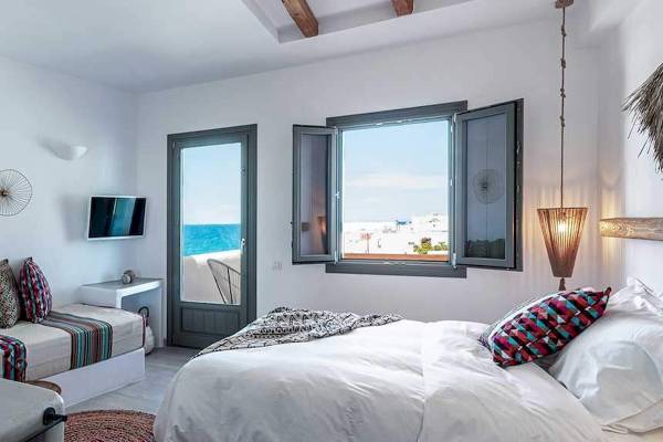 Schlafzimmer im Mythic Hotel mit Meerblick und Doppelbett