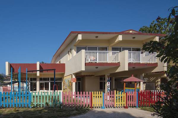 Außenansicht des Gran Caribe Villa Tortuga Hotels mit buntem Spielplatz davor.