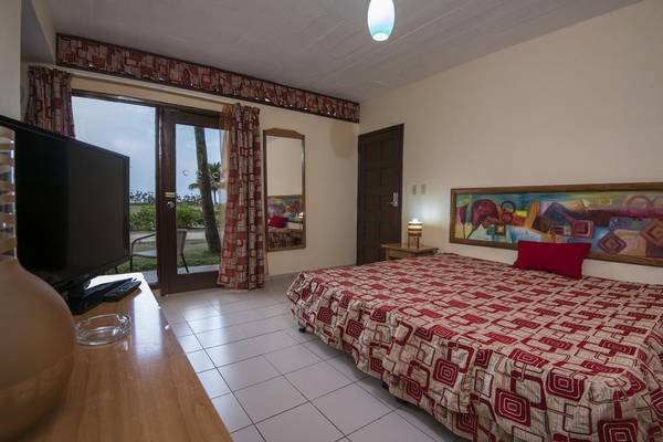 Hotelzimmer im Gran Caribe Villa Tortuga mit einem Bett, Fernseher und offenem Balkon.