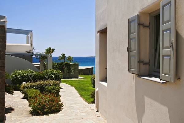 Außenansicht des Poseidon of Paros Hotel & Spa mit einem offenen Fenster und Blick auf das Meer.