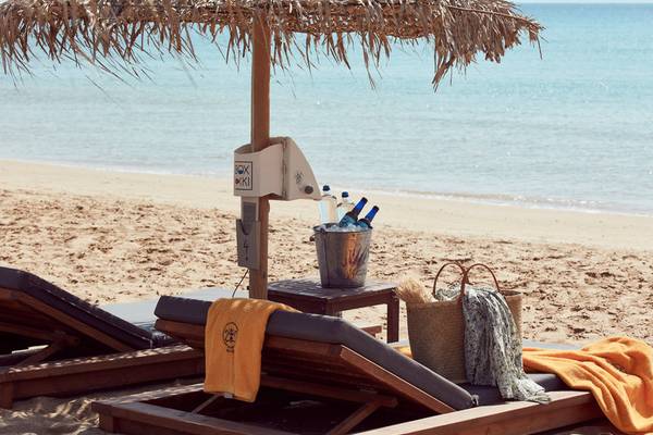 Strandliegen mit Sonnenschirm und Getränken neben dem Poseidon of Paros Hotel & Spa