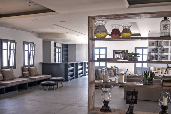 Innenbereich des Poseidon of Paros Hotel & Spa mit Sitzbereich, Couch, Regal und Dekor