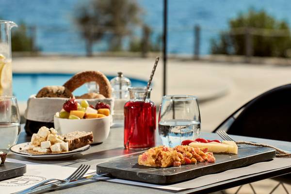 Frühstückstisch im Poseidon of Paros Hotel & Spa mit Blick auf den Pool