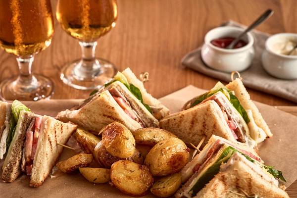 Club-Sandwich mit Kartoffeln auf dem Tisch im Poseidon of Paros Hotel & Spa