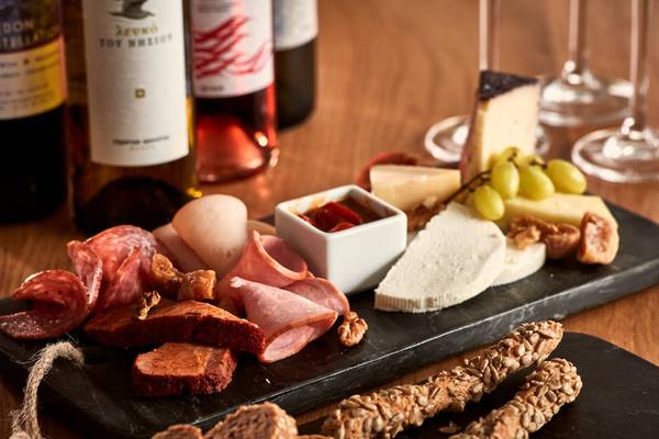 Poseidon of Paros Hotel & Spa Speiseplatte mit Käse, Fleisch, Wein und Brot.