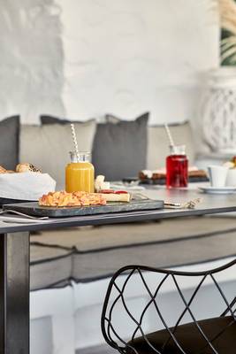 Frühstückstisch im Poseidon of Paros Hotel & Spa mit Getränken und Speisen.