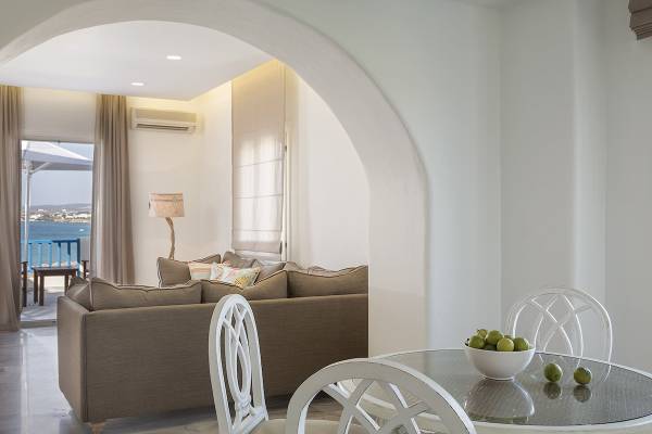 Poseidon of Paros Hotel, Wohnzimmer mit Couch und Tisch und Blick auf den Balkon.
