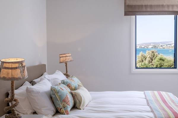 Zimmer im Poseidon of Paros Hotel mit Blick auf das Meer und eine Stadt.