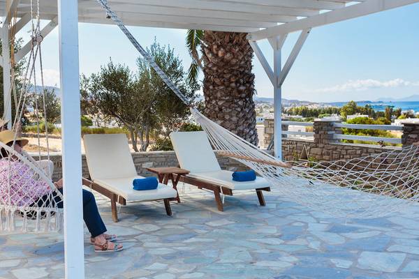 Terrasse mit Hängematte und Lounge-Stühlen im Pyrgaki Hotel mit Blick auf den Ozean.