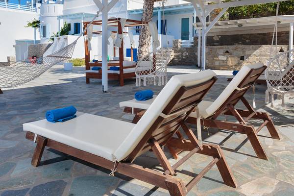 Lounge-Stühle und Hängematten im Pyrgaki Hotel mit Blick auf ein weißes Gebäude.