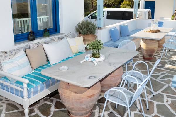 Die Terrasse des Pyrgaki Hotels mit Möbeln, Kissen und Pflanzen.