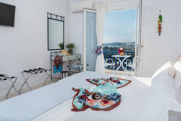 Schlafzimmer mit Balkon im Pyrgaki Hotel, mit Bett, Klimaanlage, Fernseher und Blick auf die Landschaft.
