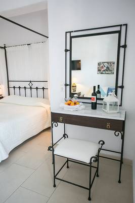 Schlafzimmer mit Bett, Kommode und Spiegel im Pyrgaki Hotel.