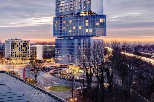 Luftaufnahme des nhow Amsterdam RAI Gebäudes bei Sonnenuntergang.