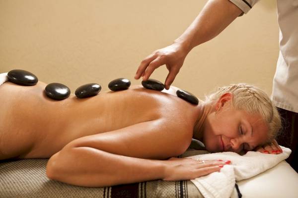 Eine Frau im Hotel Lella Baya & Thalasso genießt eine entspannende Steinmassage.