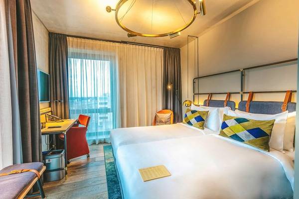 Doppelbett-Zimmer im Four Elements Hotel Amsterdam mit Blick auf die Stadt.