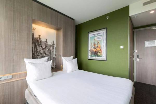 Leonardo Hotel Amsterdam Rembrandtpark Zimmer mit grünen Wänden und einem Bild an der Wand.