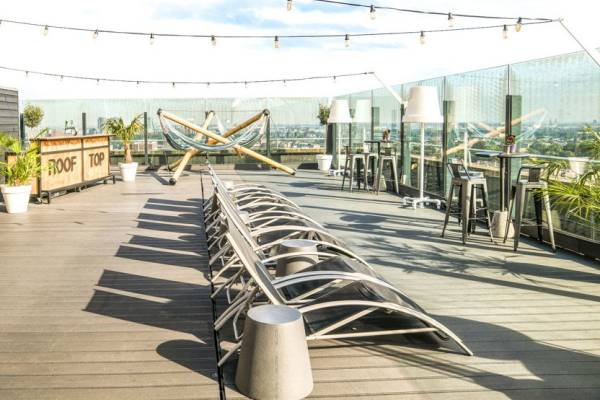 Leonardo Hotel Amsterdam Rembrandtpark Dachterrasse mit Liegen und Tischen