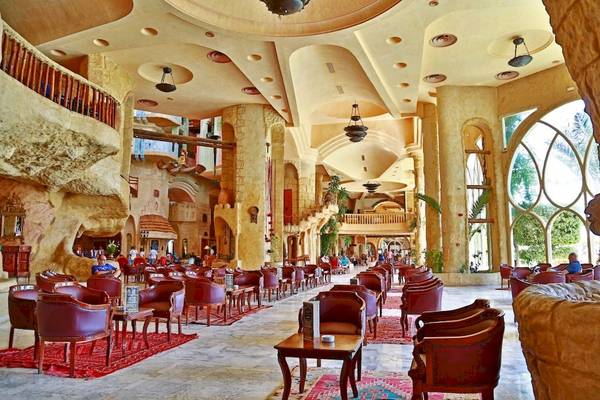 Innenbereich des Lella Baya & Thalasso Hotels mit vielen roten Stühlen und Tischen.