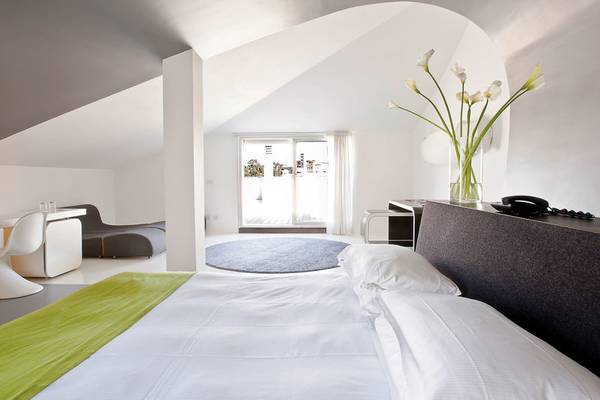Schlafzimmer im Ripa Roma Hotel mit weißem Bett, grüner Decke und heller Einrichtung.