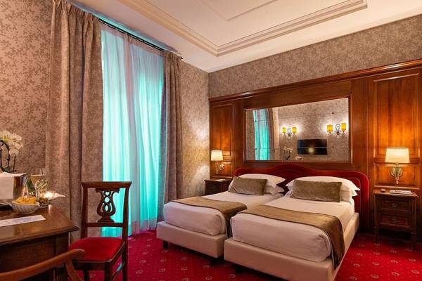 Zwei Doppelbetten in einem eleganten Hotelzimmer des Atlante Star