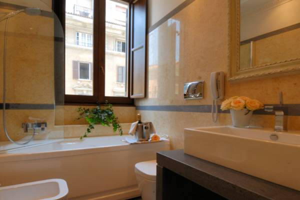 Das Badezimmer im Atlante Star Hotel mit Badewanne, Dusche, Toilette und Waschbecken.