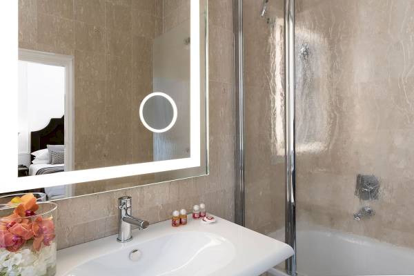 Badezimmer des Bettoja Hotel Massimo d'Azeglio mit Waschbecken, Spiegel und Badewanne