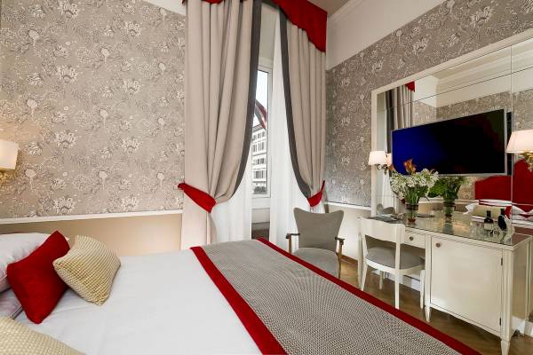 Ein elegantes Hotelzimmer im Bettoja Hotel Massimo d'Azeglio mit einem Bett, Dekor und Möbeln.
