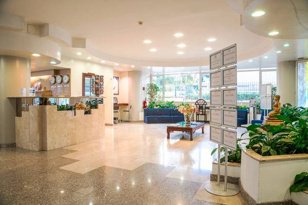 Empfangsbereich des Pineta Palace Hotels mit Rezeptionstresen, Sofas, Pflanzen und Dekor.