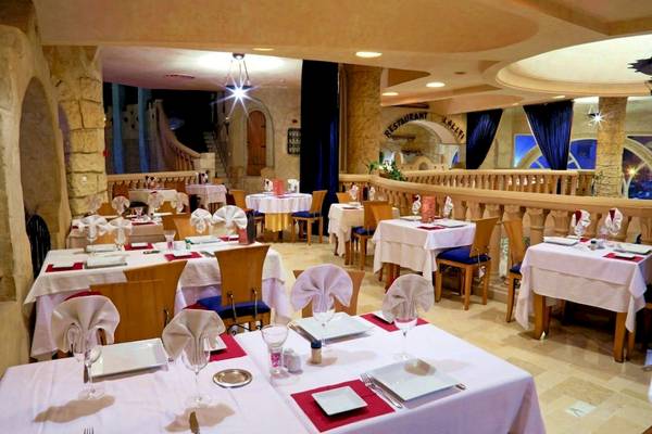 Innenansicht des Restaurants im Lella Baya & Thalasso Hotel mit gedeckten Tischen und Stühlen.