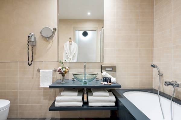 Badezimmer im Leonardo Boutique Hotel Rome Termini mit Badewanne, Waschbecken und Toilette.