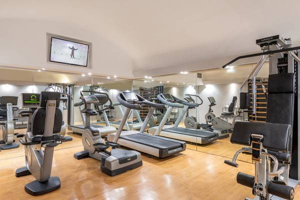 Fitnessraum im Leonardo Boutique Hotel Rome Termini mit Laufbändern und anderen Geräten.