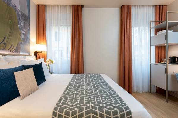 Doppelbett im Hotelzimmer von Leonardo Boutique Hotel Rome Termini mit gemusterter Bettdecke