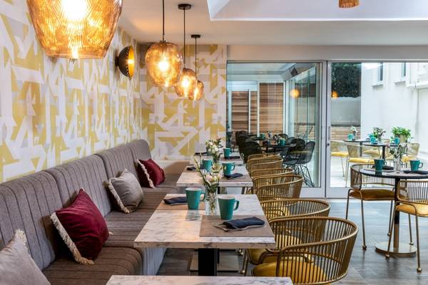 Speisebereich des Leonardo Boutique Hotel Rome Termini mit modernen Möbeln und kunstvollen Wandmustern.