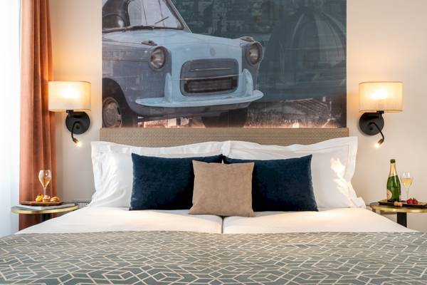 Doppelbett im Leonardo Boutique Hotel Rome Termini mit Kissen und Dekor.