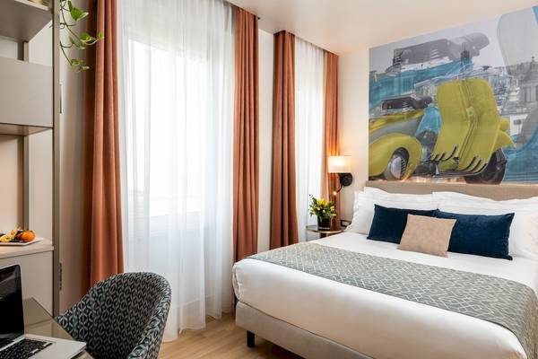 Zimmer im Leonardo Boutique Hotel Rome Termini mit Bett, Schreibtisch und Stadtansicht