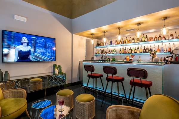 Hotellounge mit Bar, Fernseher und verschiedenen Möbeln im Leonardo Boutique Hotel Rome Termini.