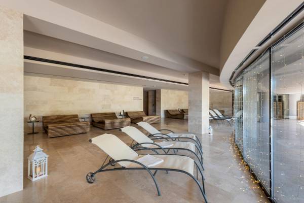Innenbereich des A.Roma Lifestyle Hotel mit Lounge-Bereich und weißen Liegestühlen.