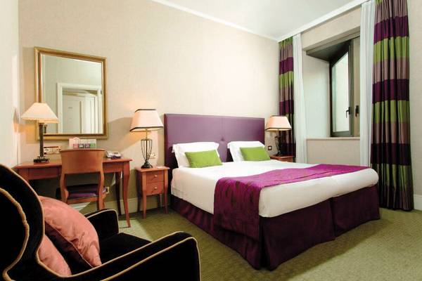 Schlafzimmer im Dei Mellini Hotel mit einem Bett, Schreibtisch, Stuhl und Dekor