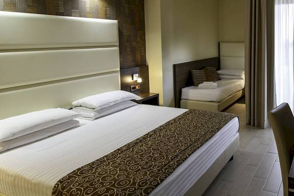 Doppelbettzimmer im Pineta Palace Hotel mit bequemen Betten und Nachttischen