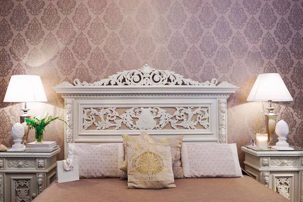 Metropole Hotel Schlafzimmer mit kunstvollen Bettkopfteil und Dekoration.