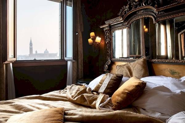 Luxuriöses Schlafzimmer mit opulentem Bett und Blick auf Venedig.