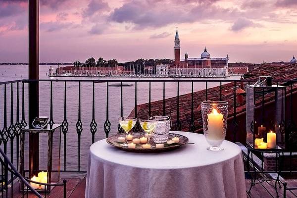 Metropole Hotel Balkon mit Ausblick auf Venedig, bei Sonnenuntergang, mit Kerzen auf dem Tisch.