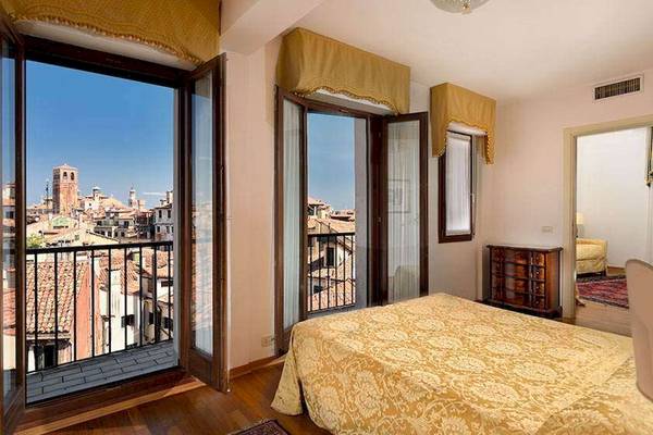 Schlafzimmer mit Balkon und Blick auf die Stadt im San Marco Palace Hotel