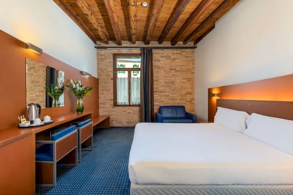 Eurostars Residenza Cannaregio Hotel Zimmer mit Bett, Schreibtisch und Fenstern.
