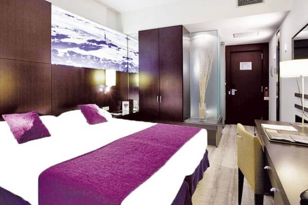 Hotelzimmer im Vincci Maritimo mit violettem Bettlaken und Dekor.