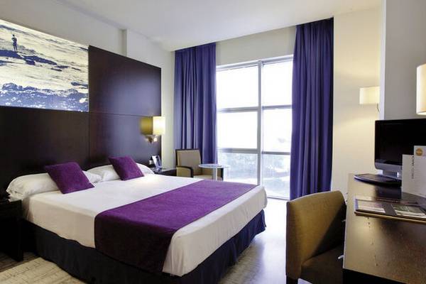 Doppelbett-Zimmer im Vincci Maritimo Hotel mit moderner Einrichtung und Panoramafenster.