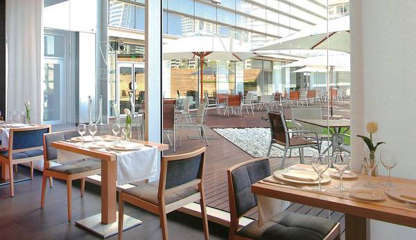 Innenbereich des Vincci Maritimo Restaurants mit gedeckten Tischen und Stühlen.