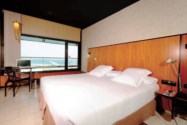 Zimmer im Barcelona Princess Hotel mit Meerblick, einem Bett, Schreibtisch und Fenster.